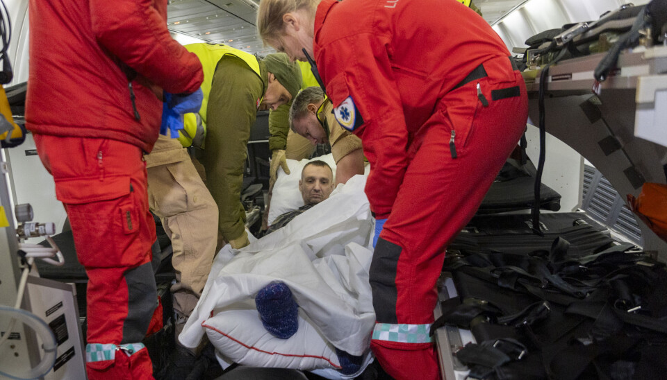 TRANSPORT: En pasient fra Ukraina blir gjort klart og fraktet ut fra flyet som har flydd fra Polen med pasienter og pårørende fra Ukraina til sykehus i Europa. Frederik Ringnes/Forsvaret. Pasient transporteres med MEDEVAC-fly
