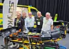 Fem personer står bak en ambulansebåre ved Emergency Norway og Strykers konferanseutstilling.