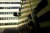 Nærbilde av en ambulanse med grønn og gul dekor foran en stor bygning.